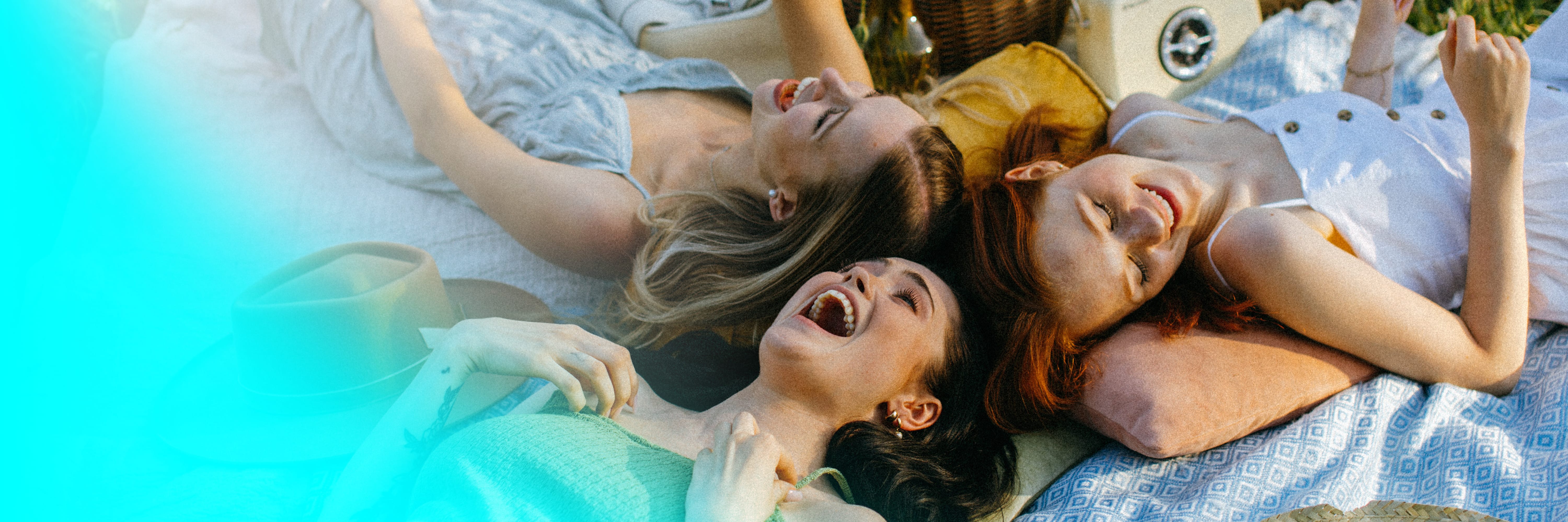 drei junge Frauen, liegend auf einer Decke