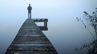 Mann einsam auf einem Seesteg