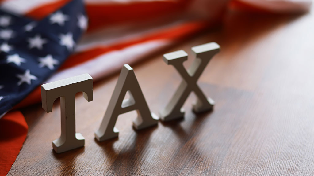 Schriftzug TAX und amerikanische Flagge